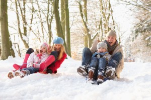the best gifts don't cost a thing, making holiday memories, how to keep the holidays stress free, how to enjoy more family time during the holidays, Family Sledging Through Snowy Woodland